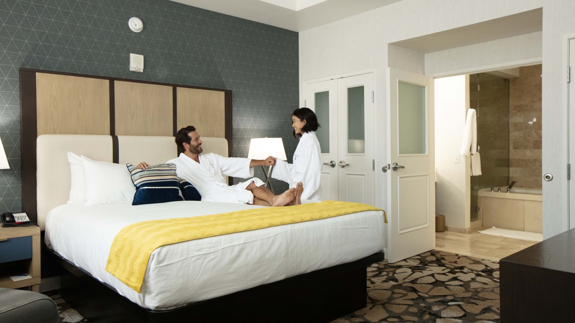 A Couple Of Men Sit On A Bed